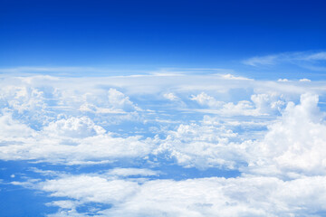 White cumulus clouds clear blue sky background, scenic aerial cloudscape view from airplane, high...