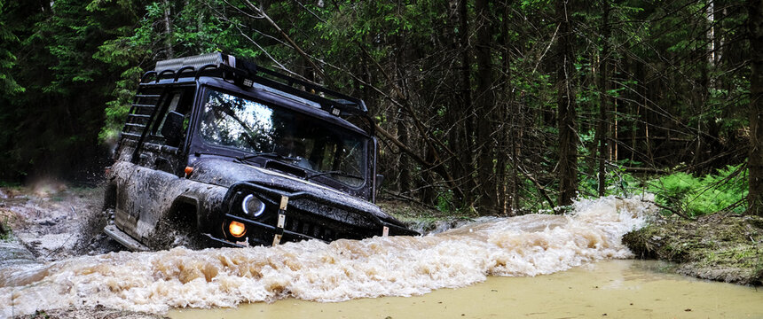 Extreme driving, challenge and 4x4 vehicles concept. Offroad race in forest. SUV or offroad car. car rides in a deep puddle