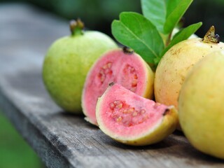 Red guava and green leaves on bokeh background. Tropical fruit concept