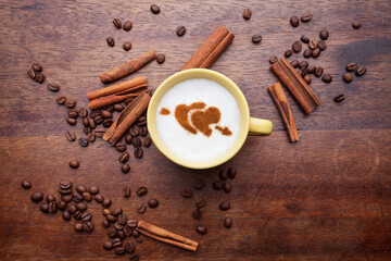 A retro cup with coffee cream. Food art creative concept image, cute drawing with cinnamon powder over milk cream on a wooden background.