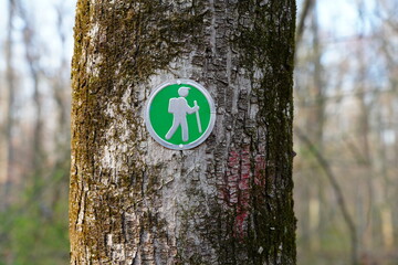 View of a hiking trail sign on a tree trunk in the woods