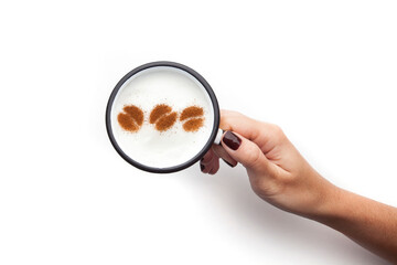 A retro cup with coffee cream. Food art creative concept image, cute drawing with cinnamon powder over milk cream on a white background.