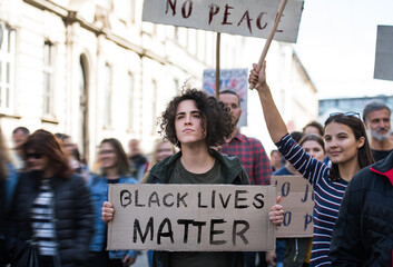 Black lives matters protesters holding signs and marching outdoors in streets.