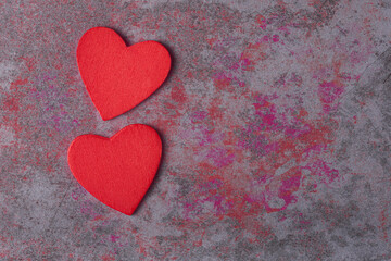 Obraz premium Two red hearts on color stone background with copy space