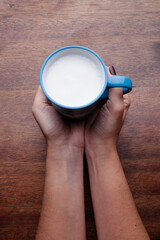 A rustic mug with coffee cream. Food art creative concept image, drawing with cinnamon powder over wooden background.