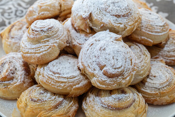 Puff pastry cakes twisted into the shape of a snail sprinkled with sugar.