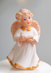Fototapeta premium figurine of an angel holding a book in his hands