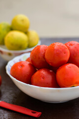Red organic tomatoes and limes in blurry background