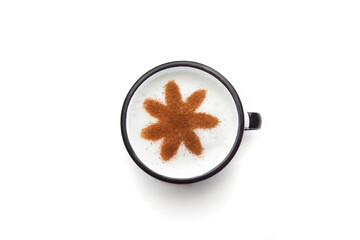 A rustic mug with coffee cream. Food art creative concept image, drawing with cinnamon powder over milk cream in a white background.