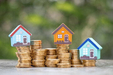 Money Financial, Business Growth,loan and real estate investment concept. house model on gold coins to stack of coins.