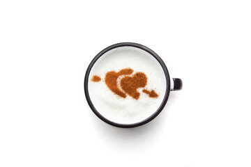 A rustic mug with coffee cream. Food art creative concept image, drawing with cinnamon powder over milk cream in a white background.