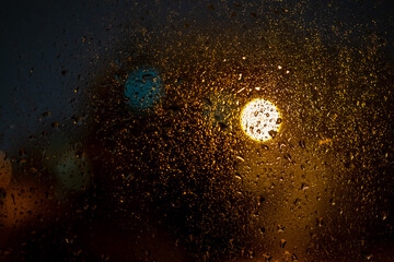 Raindrops on a window with abstract blurred colored lights