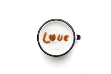 A rustic mug with coffee cream. Food art creative concept image, drawing with cinnamon powder over milk cream in a white background.