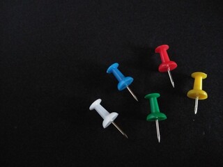 colorful push pins isolated on black background