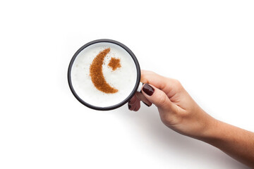 A rustic mug with coffee cream. Food art creative concept image, drawing with cinnamon powder over cream in a white background.
