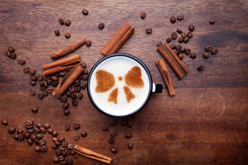 A rustic mug with coffee cream. Food art creative concept image, drawing with cinnamon powder over...