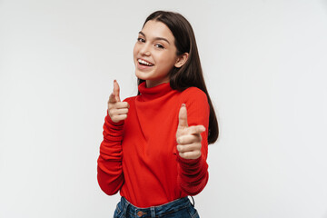 Photo of cheerful young woman smiling and pointing fingers at camera