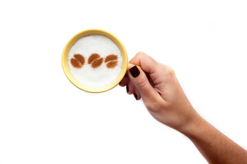 A rustic mug with coffee cream. Food art creative concept image, drawing with cinnamon powder over cream in a white background.
