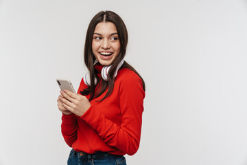 Fototapeta premium Photo of happy caucasian woman smiling while using cellphone and headphones