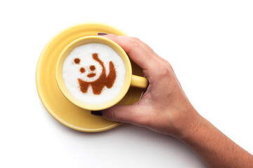 A rustic mug with coffee cream. Food art creative concept image, drawing with cinnamon powder over cream in a white background.

