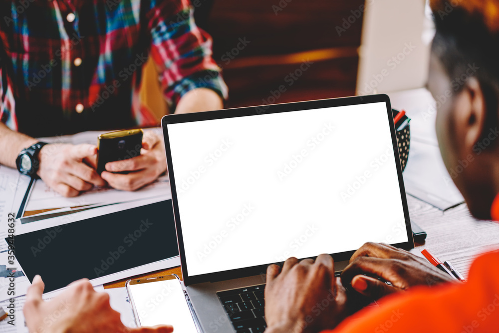 Poster cropped back view of dark skinned blogger updating software on modern laptop device with copy space 