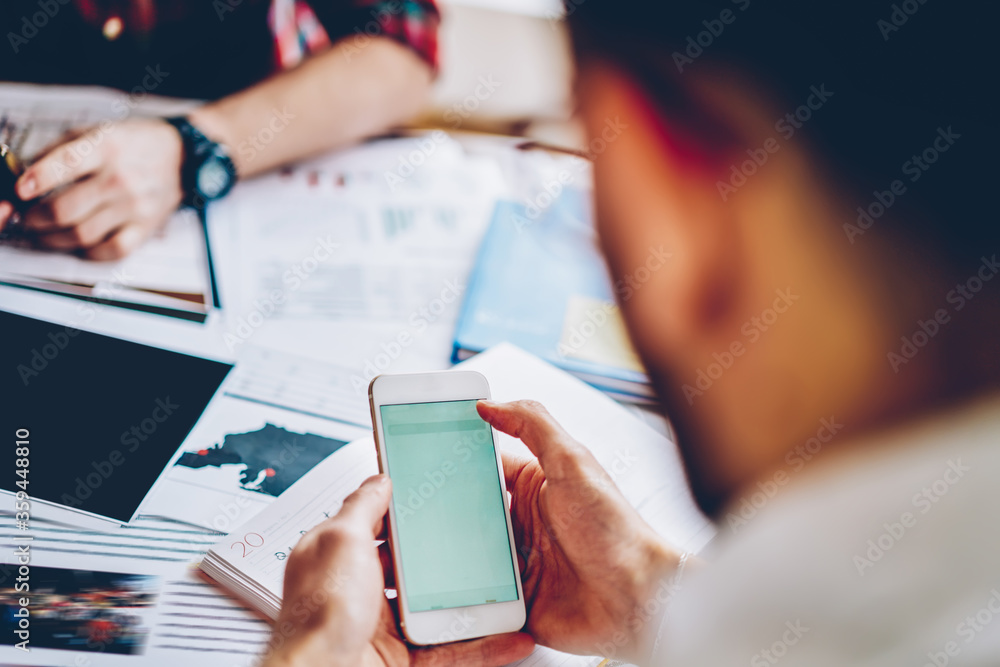 Poster cropped view of young man holding modern smartphone in hands to download files from websites via 4g 