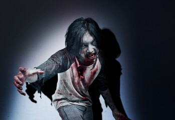 Scary zombie with blood and wound on his body standing