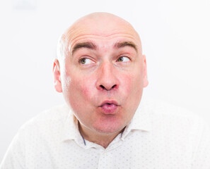 portrait of bald adult mature man with emotions on white background