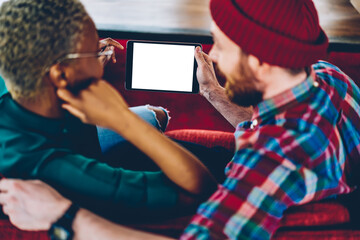 Cropped back view of young marriage discussing choose movie to watch on modern touch pad device with blank screen are for your website.Couple in love installing app on digital tablet using 4G internet