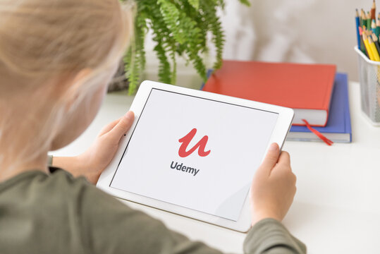 January 5, 2020, Kaliningrad, Russia. Udemy application start-up screen. Young girl holding iPad in her hands with Udemy application on the screen. Udemy Streaming Application