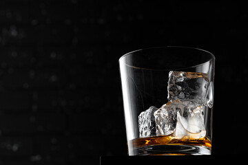 Whisky glass against dark black grunge wall