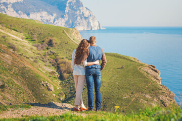 Young couple in love outdoor.Stunning sensual outdoor portrait of young stylish fashion couple posing on the background of mountains and sea