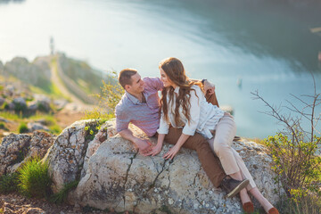 Young couple in love outdoor.Stunning sensual outdoor portrait of young stylish fashion couple posing on the background of mountains and sea