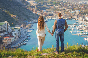 Young couple in love outdoor.Stunning sensual outdoor portrait of young stylish fashion couple posing on the background of mountains and sea