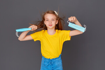 Concept of stopping the coronavirus quarantine. The girl brandishes two medical masks after...