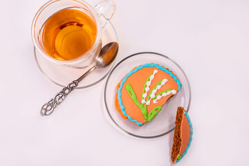 Glass Cup of black tea and a beautiful gingerbread on a white background. The concept of a delicious Breakfast.