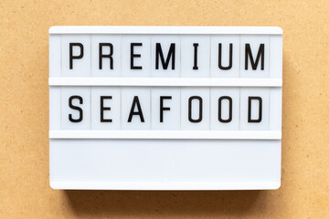 Lightbox with word premium seafood on wood background