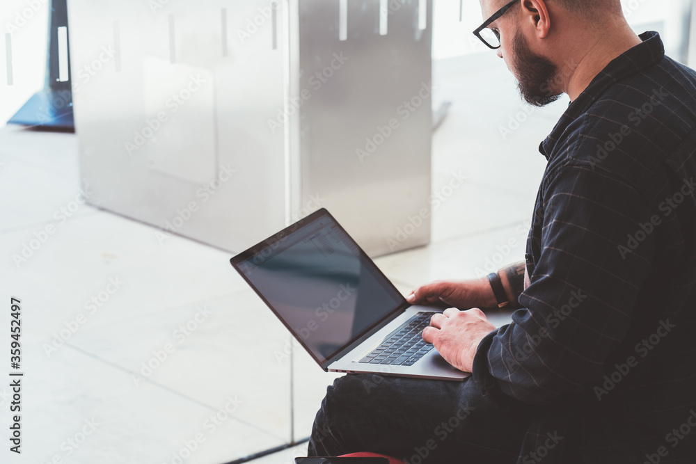 Poster cropped view of bearded male freelancer installing app for remote work at modern laptop device with 