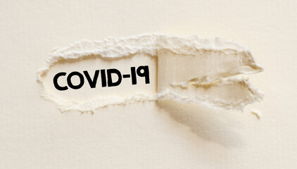 COVID-19 words written on a white piece of paper.