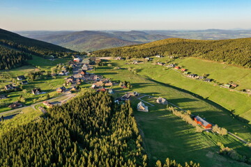 Naklejka premium Mountain hut in forested hilly landscape, Pomezni Boudy, Krkonose, Czech Republic