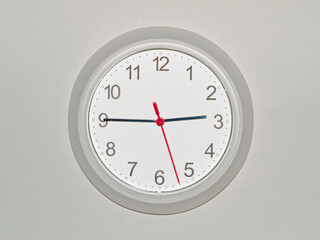 eine Wanduhr auf grauem Hintergrund zeigt die Zeit 02:45 Uhr