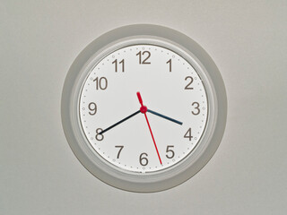 eine Wanduhr auf grauem Hintergrund zeigt die Zeit 03:40 Uhr