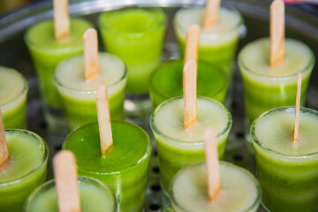 Close up a lot of cup of green layer sweet cake in a stainless steel steamer pot, modern Thai sweet concept.