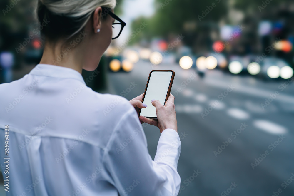 Aufkleber cropped back view of hipster blogger holding smartphone device and touching with fingers on blank sc