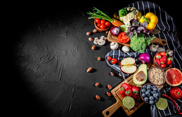 Fototapeta na wymiar Assortment of fresh fruits and vegetables on dark background. Concept of healthy food. Top view with copy space