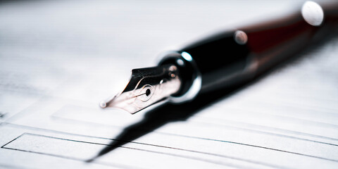 Signing the contract document with fountain pen, close-up shot.