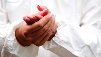 A close-up on the hands of a woman who is rubbing her hands