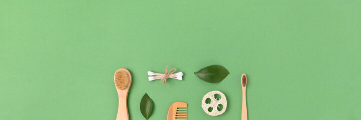 Layout of zero waste accessories for personal hygiene on a green pastel background. Banner with plastic free concept.