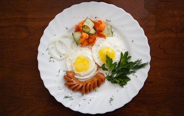 Breakfast with scrambled eggs at the hotel. Plate on a wooden background
