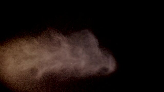 Spraynebel in Zeitlupe vor schwarzem Hintergrund